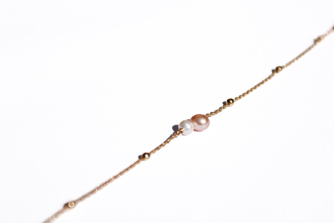 Geboortesteen armbandje met 1 roze en 1 witte parel