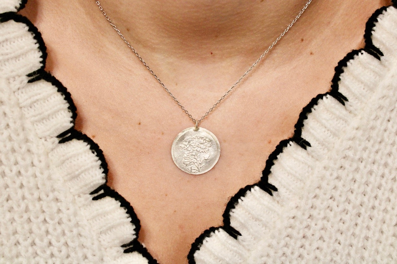 Néhlia's herinneringssieraden:  Zilveren vintage hanger met november bloem chrysant gedragen aan een fijne ketting.
