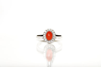 Close-up van de ovale halo-zetting met fonkelende steentjes op een zilveren vintage as-ring.