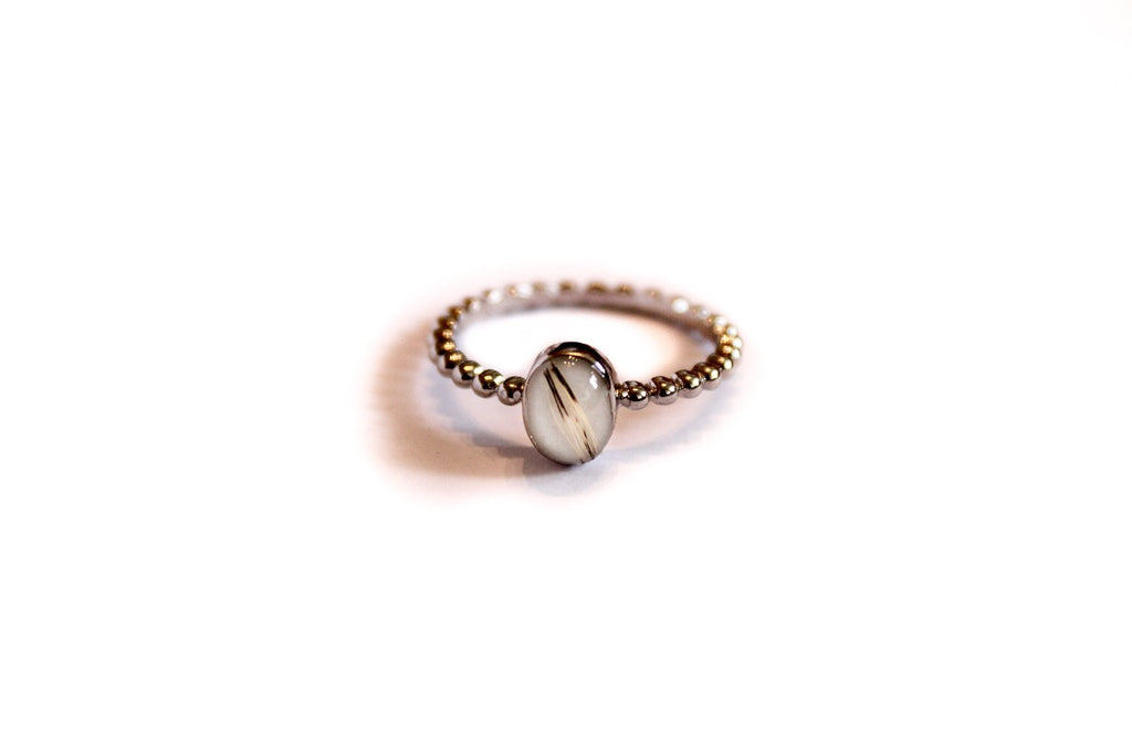 Zilveren Cira moedermelkring in solitaire stijl. Ring met ronde melkwitte herinneringssteen en kattenharen van Néhlia.