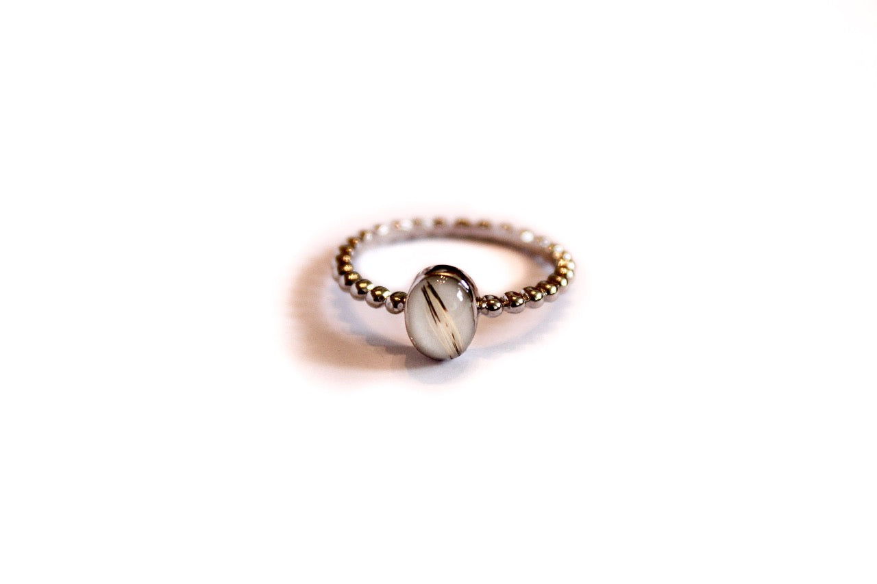 Zilveren Cira moedermelkring in solitaire stijl. Ring met ronde melkwitte herinneringssteen en kattenharen van Néhlia.