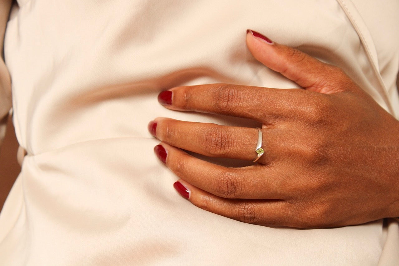 De zilveren Essence ring met augustus peridoot gedragen als persoonlijk en kleurrijk geboortesieraad.
