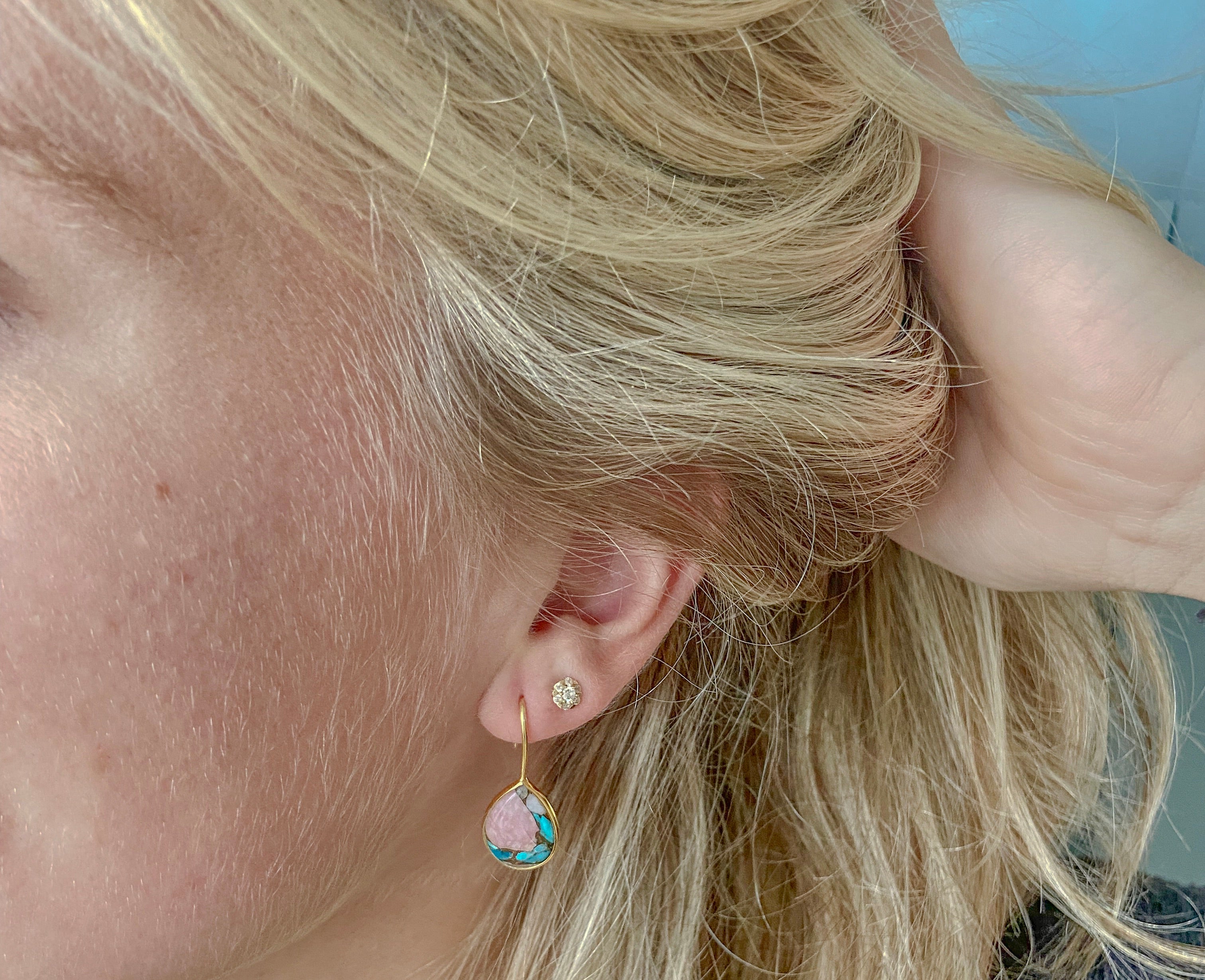 Zilveren Aia oorbellen met turquoise en roze opaal van Néhlia gedragen in vrouwen oor.