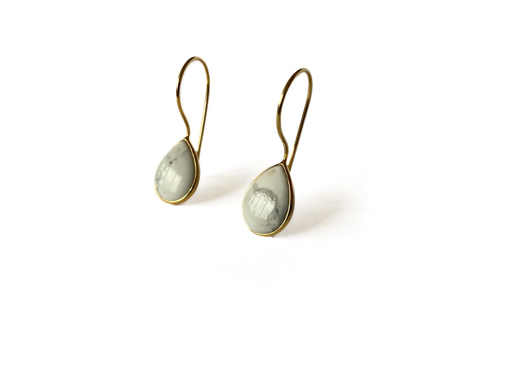 Zij aanzicht zilveren Alba oorbellen met witte marmerachtige howliet, modern strak design van Néhlia.