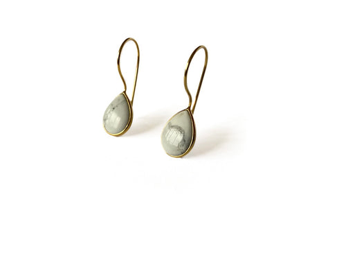 Zij aanzicht zilveren Alba oorbellen met witte marmerachtige howliet, modern strak design van Néhlia.