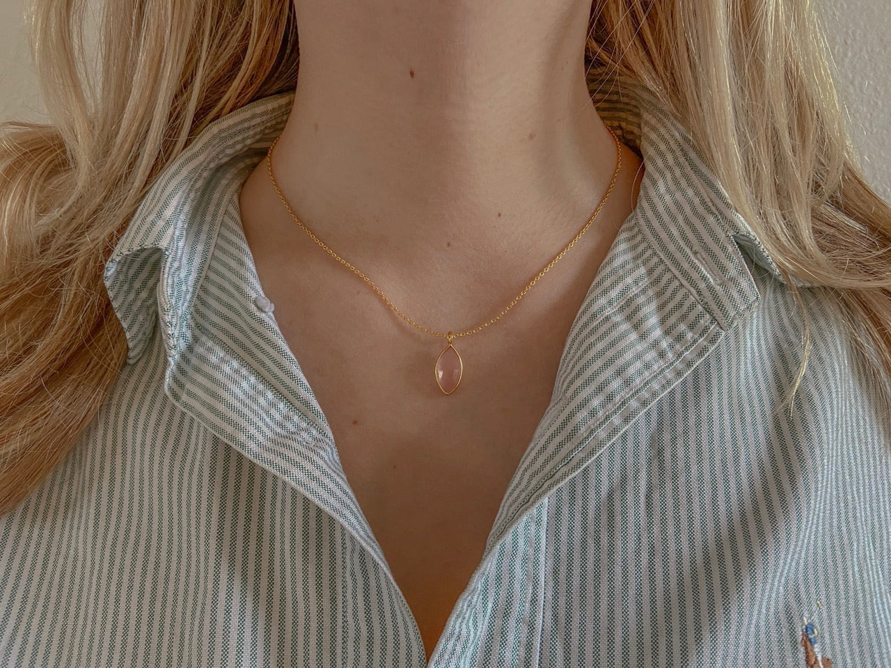 Zilveren Nava ketting met melkachtig roze chalcedoon van Néhlia gedragen om vrouwen nek.