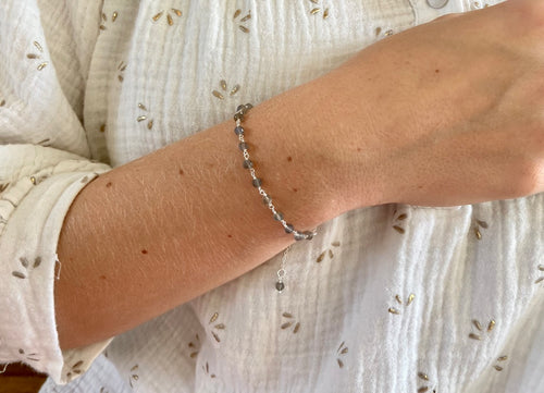 Zilveren Orb geboortesteen armbandje van Néhlia gedragen om vrouwenpols.