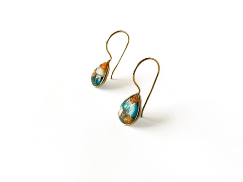 Zij-aanzicht zilveren Raya oorbellen met oranje Spiny Oyster en blauwe Arizona Turquoise, modern strak design van Néhlia.